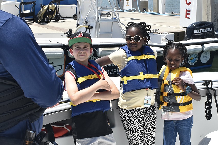 Marine Patrol Officer Michael Skinner speaks with Isabelle Nicolas, 10, and Ariann Nicolas, 8.