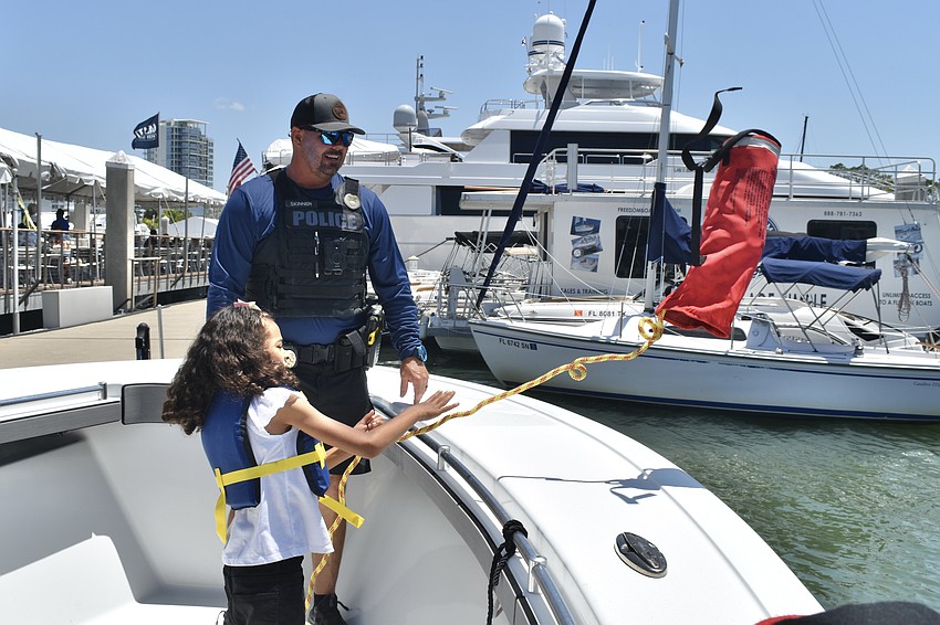Marine Patrol Officer Michael Skinner watches as Analise Gallant, 7, tosses out a rescue bag.