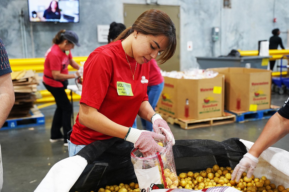 A State Farm employee helps pack food for Second Harvest Food Bank of Central Florida. Photo courtesy of Second Harvest Food Bank of Central Florida