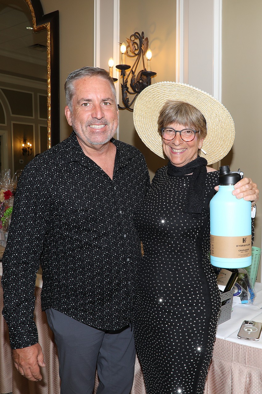 Troy Funk and Ellen Jaffe Jones peruse the silent auction donations.