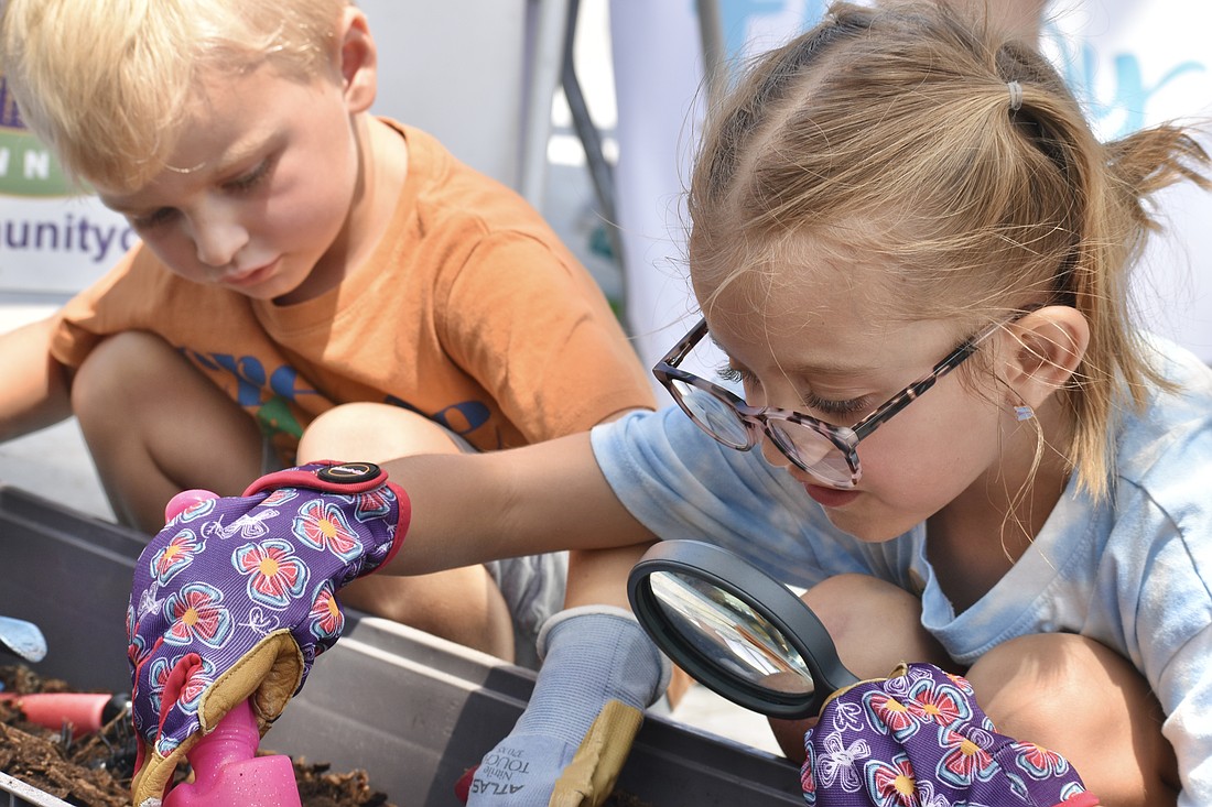 Mason Manahan, 5, and Juniper Hassler, 6, dig in a compost pile.