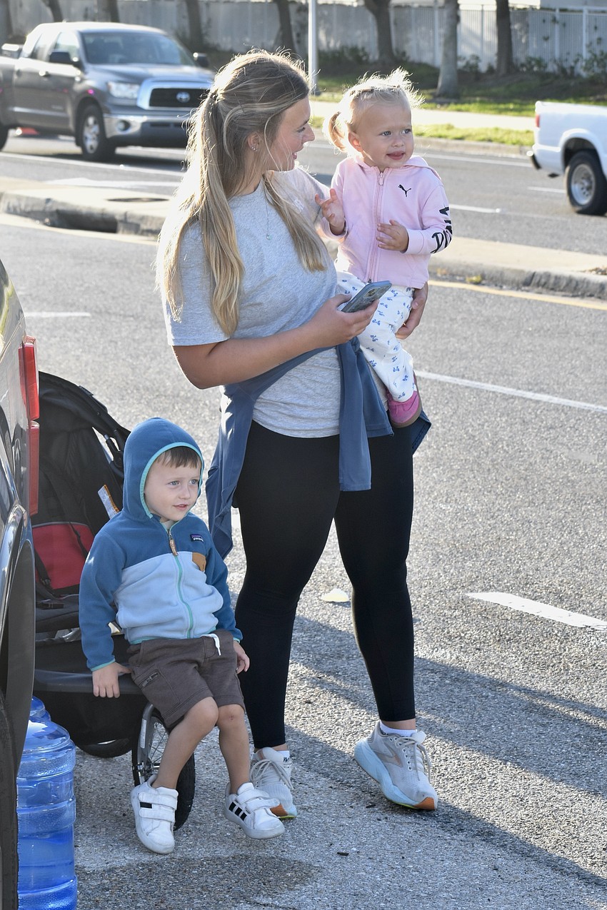 Hank Stump, 3, his mother Casey Stump, and his sister Lucy Stump, 2, watch the race.