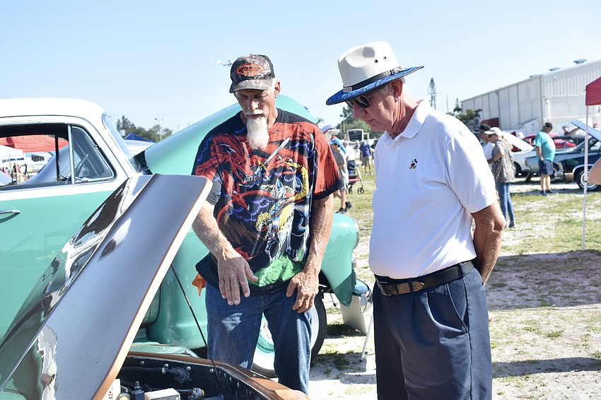 Lloyd Wallace showcases his car to Rick Coyne.
