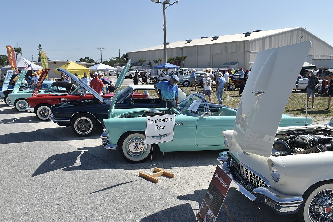 A series of Thunderbirds line the car show.