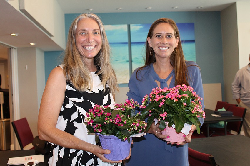 Jessica Tessier and Michelle Bernhardt from Dreamer's Academy take home flowers from the Arbor Day event.