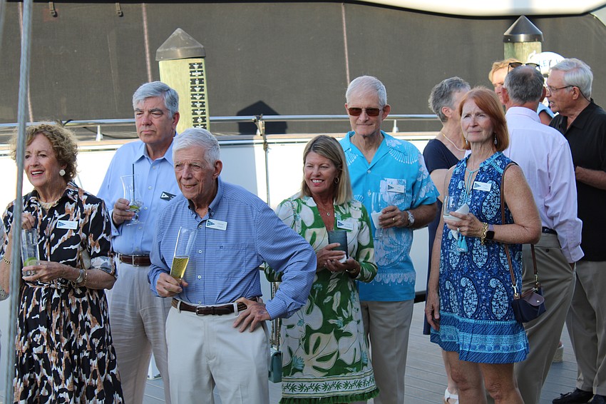 Party goers curiously peer at the time capsule, waiting to see what comes out next.