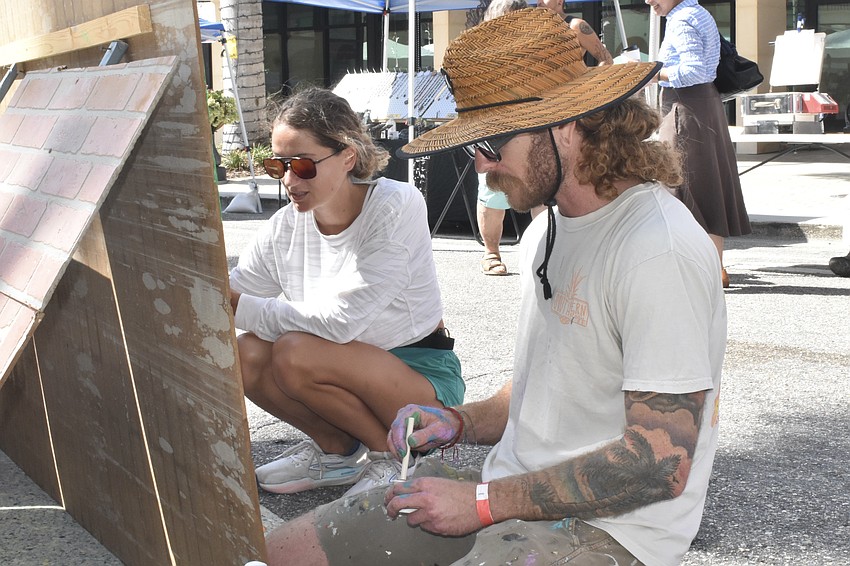 Allison Gable and Brandon Thrift work on a mural.