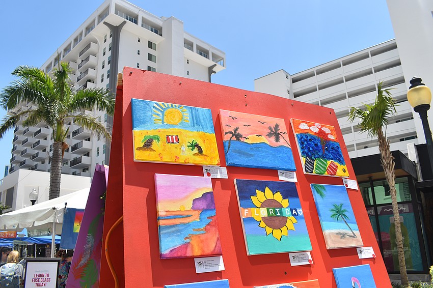 Works of art by students are displayed in the street.