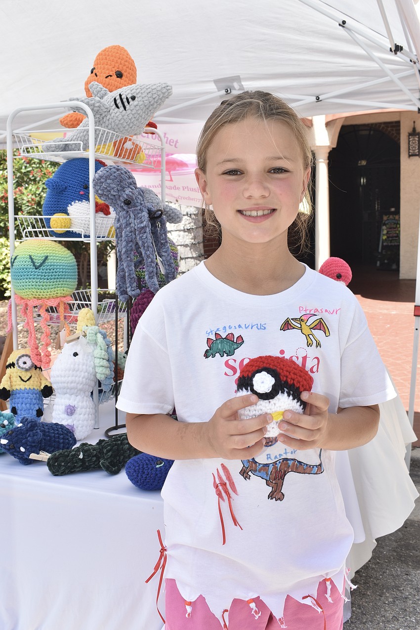 Allison Kellison, 8, buys a crochet Pokeball from Camille Feaser.