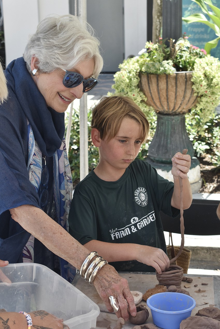 Michael Saunders and her grandson Beckett Saunders, 7, work on a pottery project.