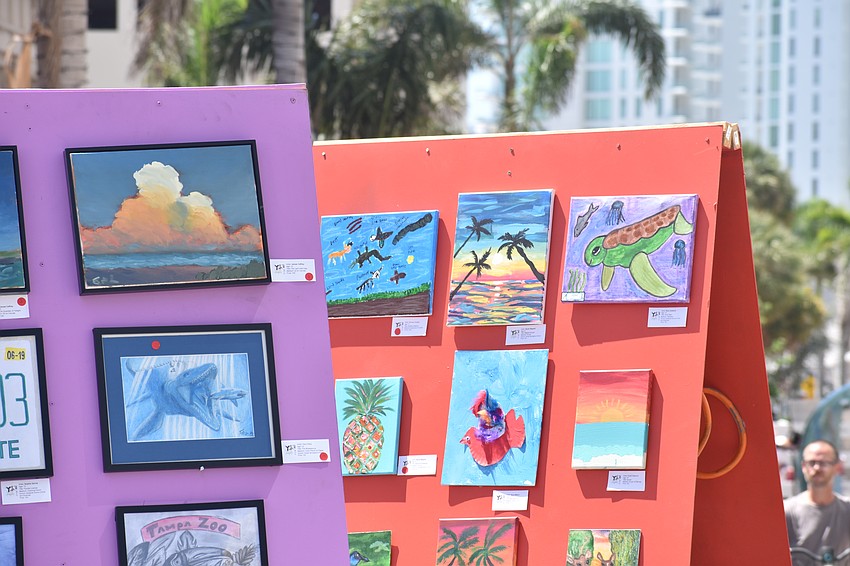 Works of art by students are displayed in the street.