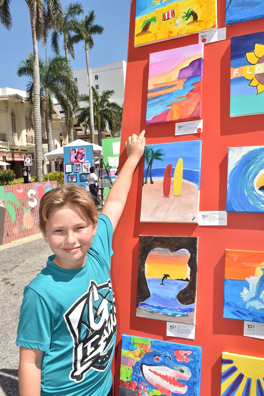 Charlie Queen, 9, showcases his sunset painting.