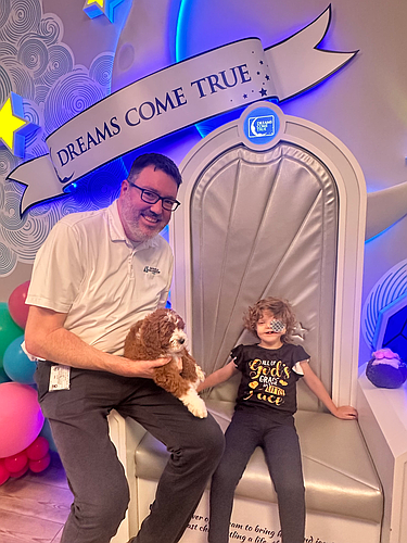Jacksonville Bar Association Executive Director Craig Shoup with 5-year-old Emma and her new Goldendoodle puppy that was her dream come true funded by the JBA’s 2024 Rendezvous on the Rooftop.