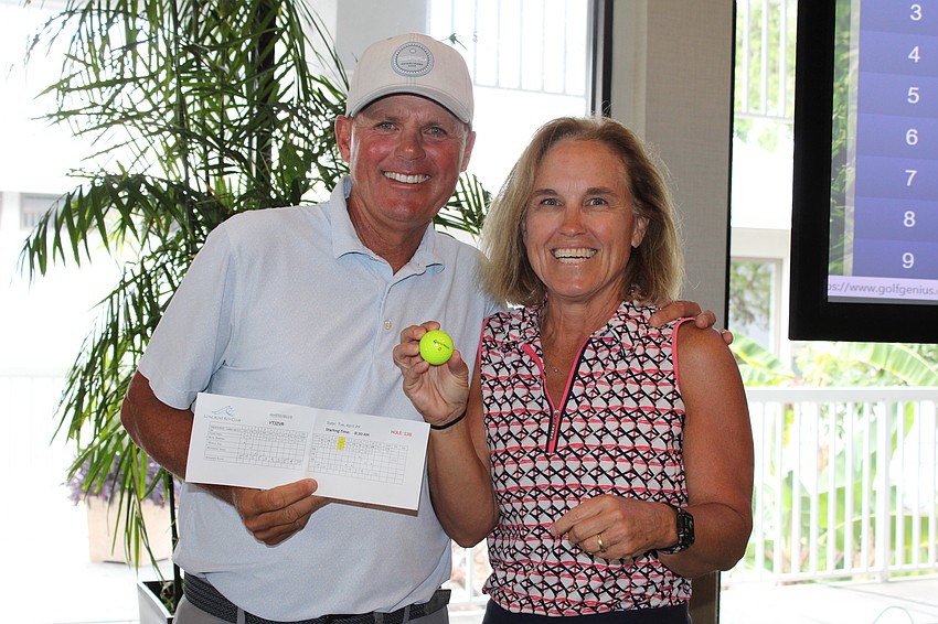 Laura Muth celebrates landing her first hole-in-one shot at the Women's Golf Association end-of-season party with Terry O'Hare, director of golf.