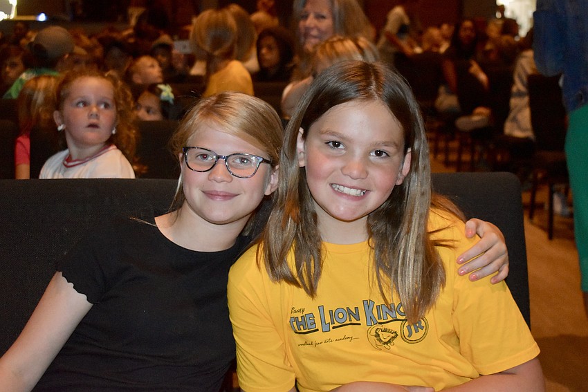Carys Di Silvestro, 9, and Gia Thress, 10, are in the audience waiting to see the costumes they designed for the show on stage.