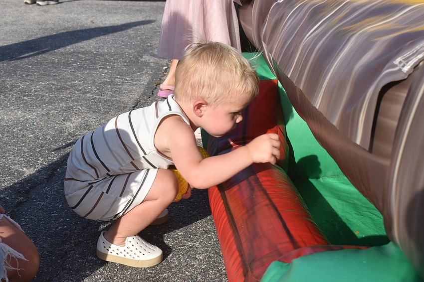 Bradenton resident 1-year-old Wyatt Parsons is fascinated by the balls rolling back to him after he threw them in skee-ball.