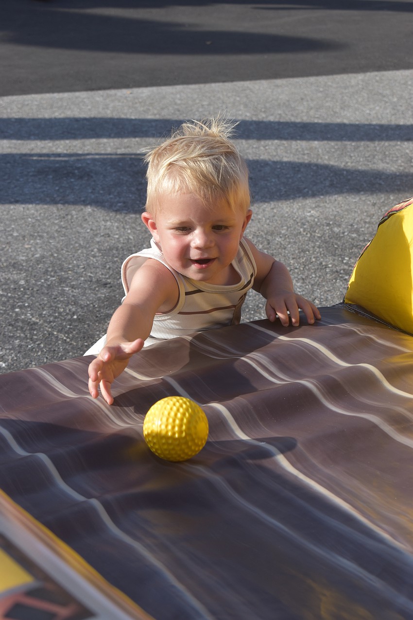 Wyatt Parsons, a 1-year-old Bradenton resident, had more fun catching the balls as they rolled down than throwing the ball into the game.