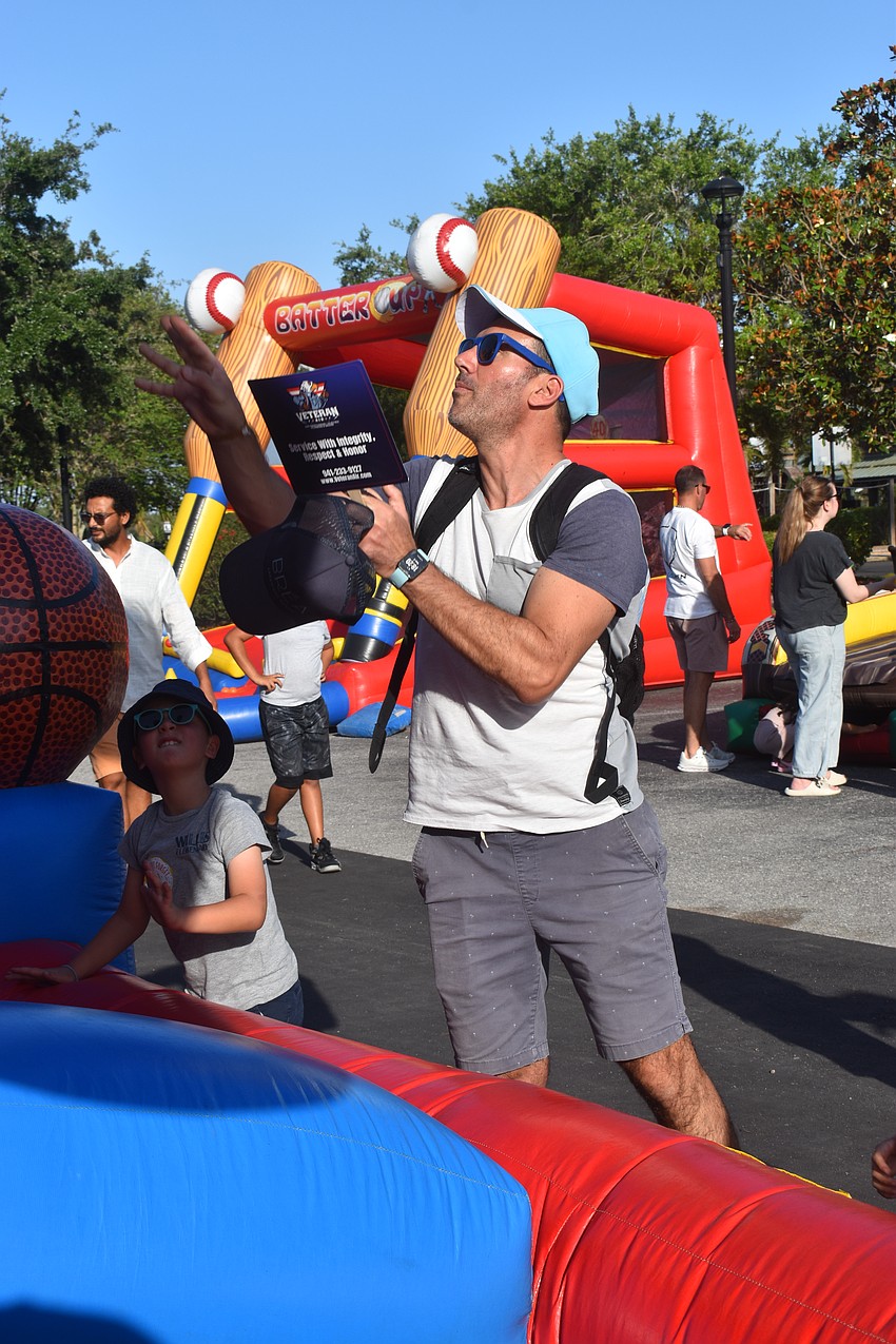 Lakewood Ranch resident Oliver Cottalorda gives advice to his 8-year-old son Alexandre Cottalorda on how to shoot.