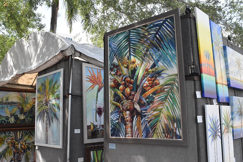 Paintings of tropical trees and plants adorn a booth at the event.