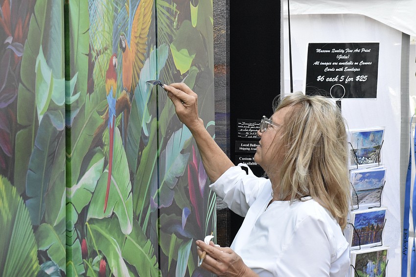 Artist April Davis puts finishing touches on a painting.