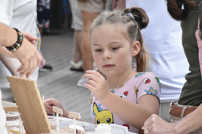 Ruby Albers, 6, examines a piece of jewelry.