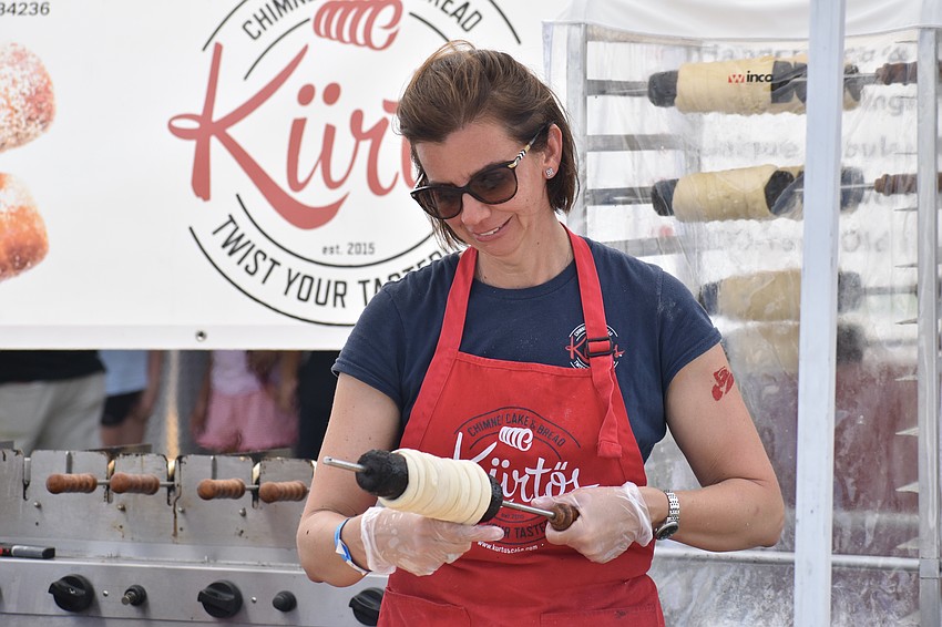 Aniko Gulyas of Kürtős Chimney Cakes on Main Street wraps one of the cakes.