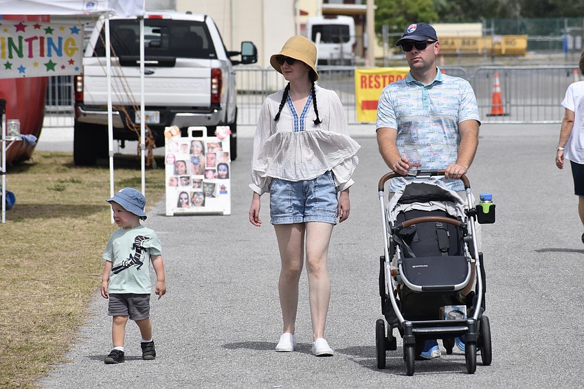 Samuel Jamboc, 2, and his parents Eniko and Eduard Jamboc walk through the festival near the kids' activities.
