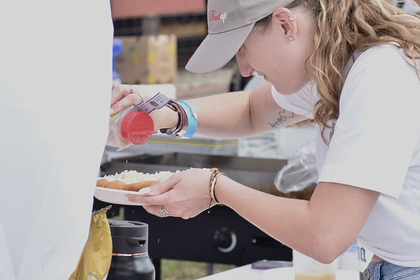 Christina Simonyi sprinkles powdered sugar on a lángos.