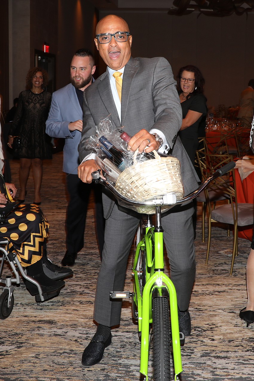 VMA's Shine On silent auction wins:  Co-chair Edward Valdez rides out of The Ora on his new bicycle complete with a wine basket.
