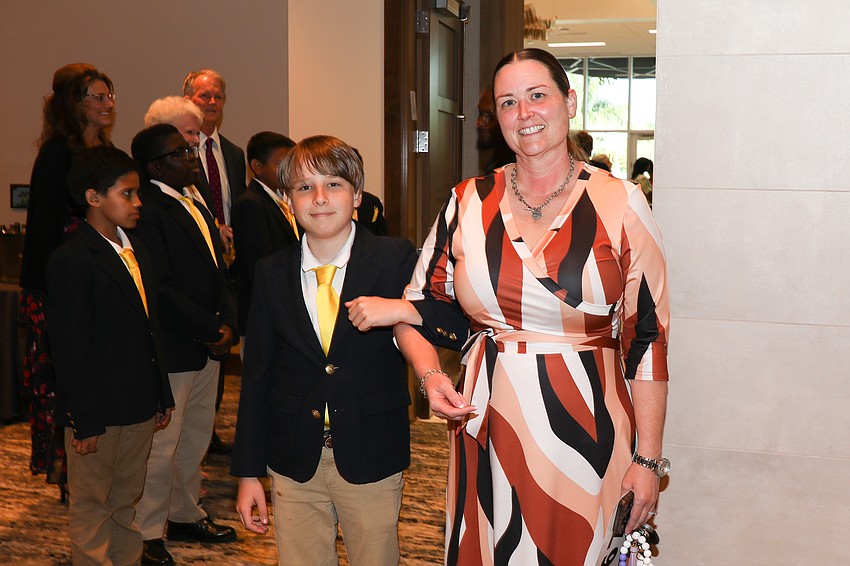 Fifth grader Wyatt Morton escorts Katie Oliver to her seat at the Shine On gala.