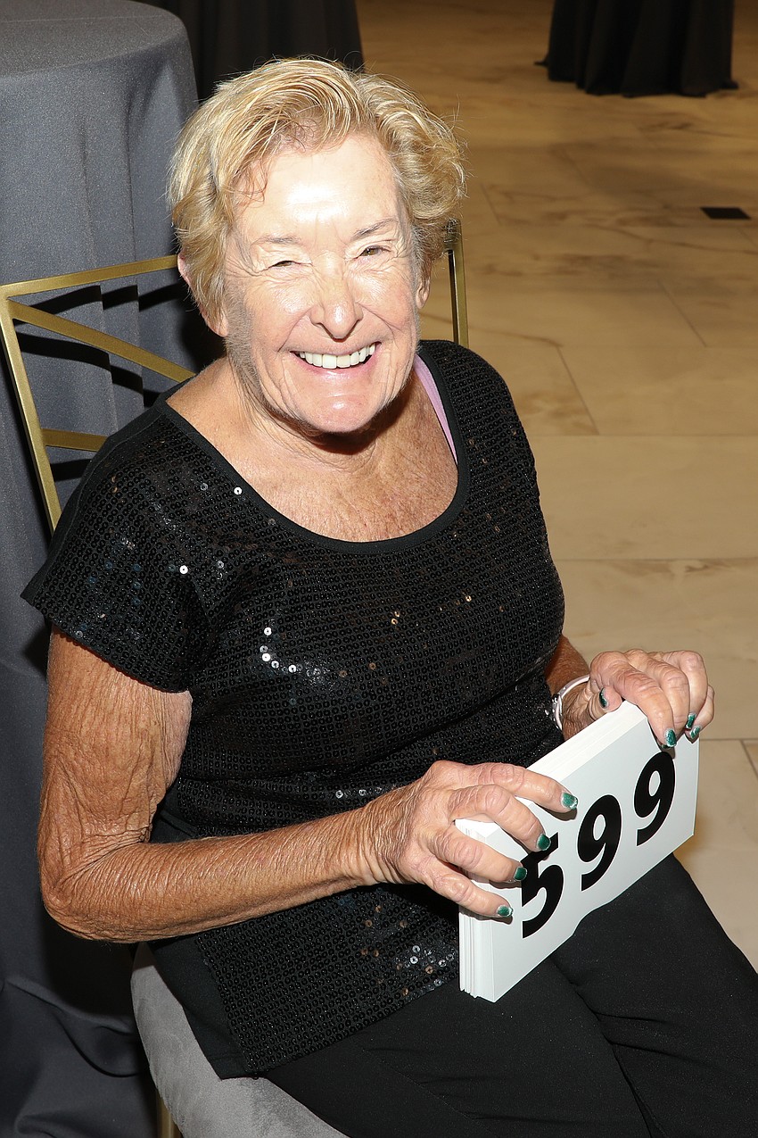Volunteer Christine Kratzer makes sure everyone gets the correct bid card as they enter the VMA Shine On gala.
