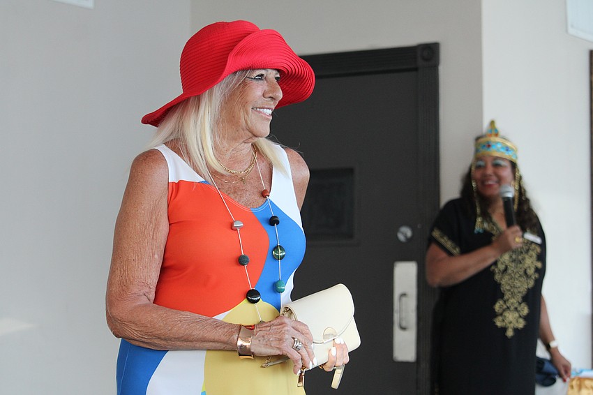 Artist Medge Jaspan looks on as Gloria Pacheco models a dress with one of her fabric designs at the FemCity fashion show fundraiser.
