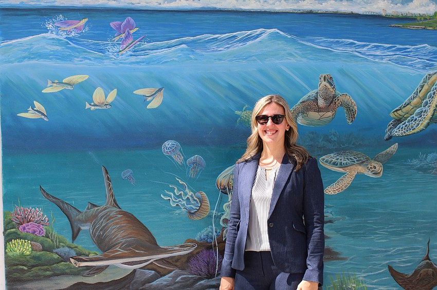 General manager Lana Jackson shares a smile with the newly refurbished and strengthened O'Leary's Tiki Bar & Grill at her back.