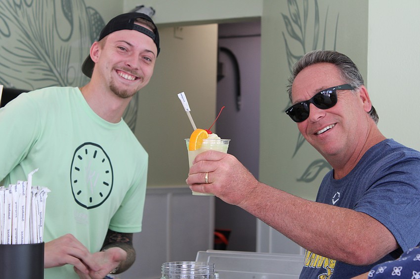 Ron Rigot, attending the grand reopening of O'Leary's Tiki Bar & Grill with wife Audrey, gives his stamp of approval for bartender T.J. McKenna's rendition of a piña colada.