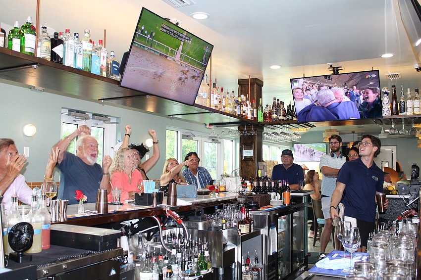 John and Gale Mulligan, left, cheer as their pick for the winner of the Kentucky Derby, Sovereignty, reaches the finish line.