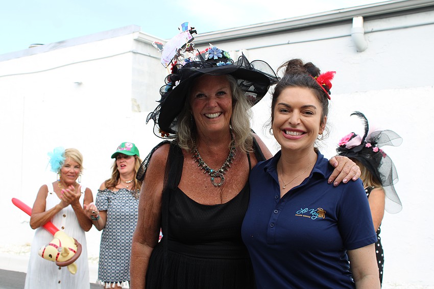 General Manager Courtney Rossler presents the award for best hat to Patrice Fanning.