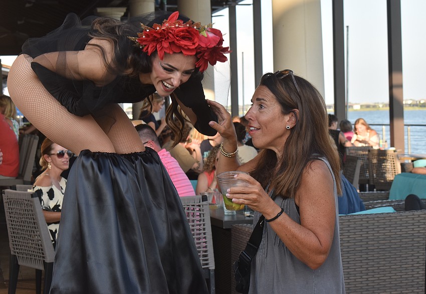 Stilt walker Natasha Eriksen gets down on Lakewood Ranch resident Michele Schweidel's level to share a laugh.