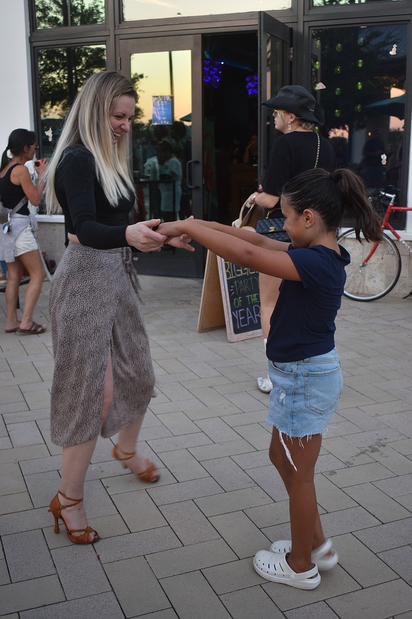 Nicolette Fornasari of Dance Fever Sarasota dances with Olivia Barfield, a 7-year-old who dances at Stage Door Studios in Sarasota during the Cinco de Mayo celebration.