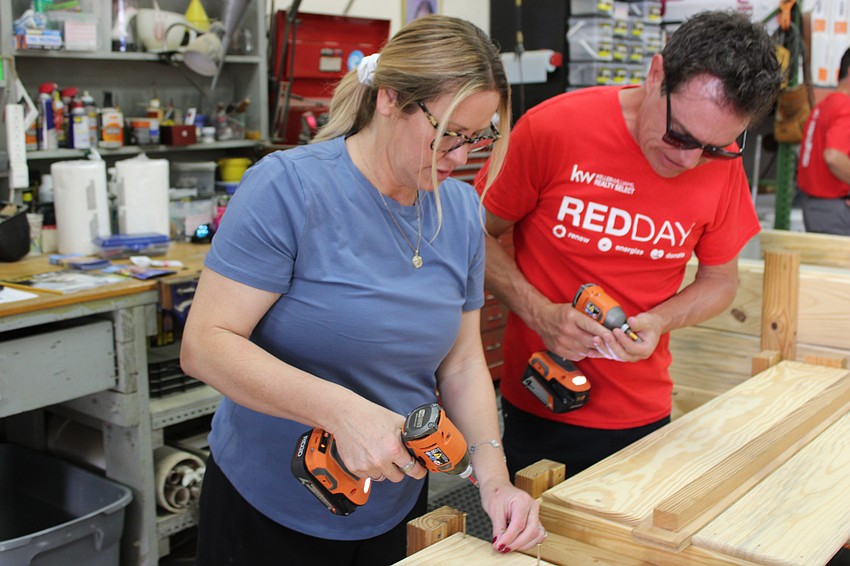 Megan Tackitt and her husband Jason, who is a Realtor for Keller Williams, work as a team building frames for Beds for Kids.