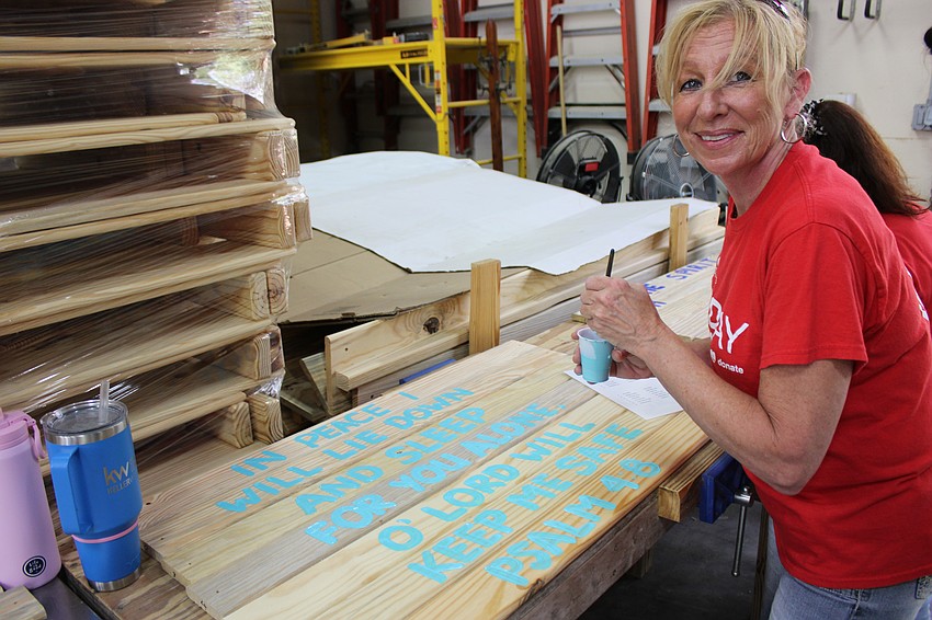 Rebecca Adams, the CEO of Keller Williams Coastal Living II, finishes a Scripture verse that will go to a child in need of a bed.