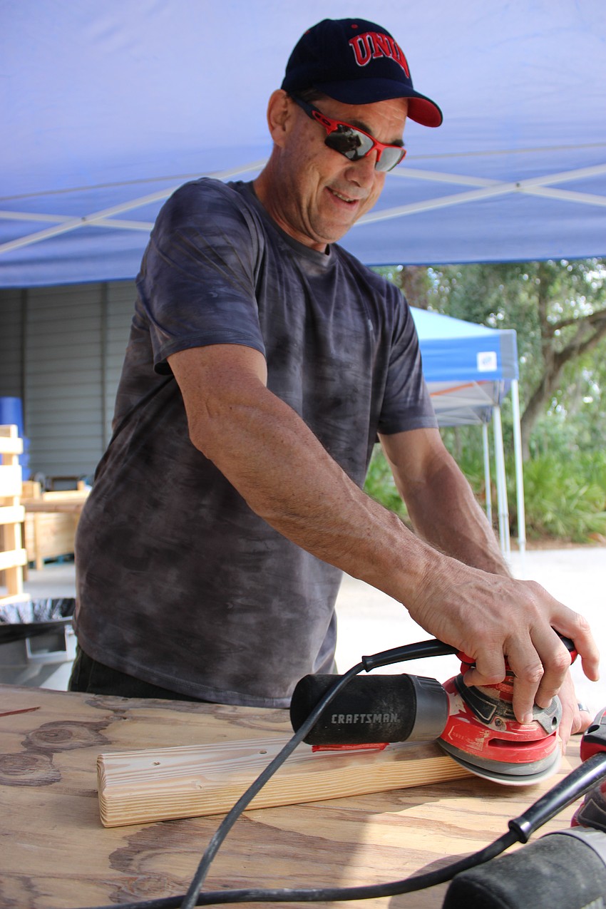 Rick Owen, who says his father was a carpenter, was doing some sanding during Red Day. He only has worked for Keller Williams two months and he was enjoying the volunteer effort.