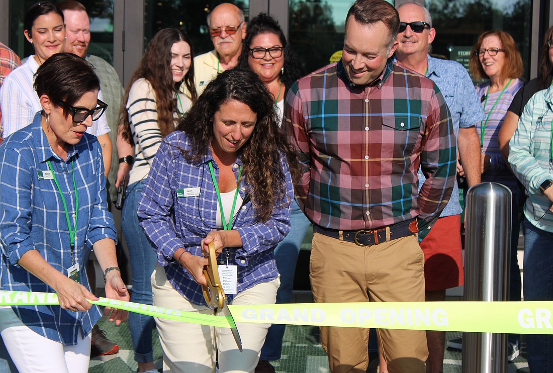 L.L. Bean District Manager Kenon Mitchell holds the ribbon while Store Manager Jennifer Molloy cuts it as L.L. Bean Vice President Corey Bouyea looks on at the store's grand opening Friday in Sarasota.