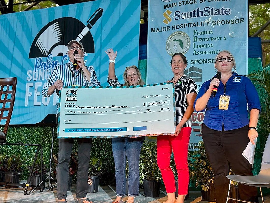 Event founder Garry Lubi presents a $3,000 check to the Flagler Education Foundation to Executive Director Teresa Rizzo and Kahn-Lien Banko, president of the Education Foundation Board of Directors. Courtesy photo