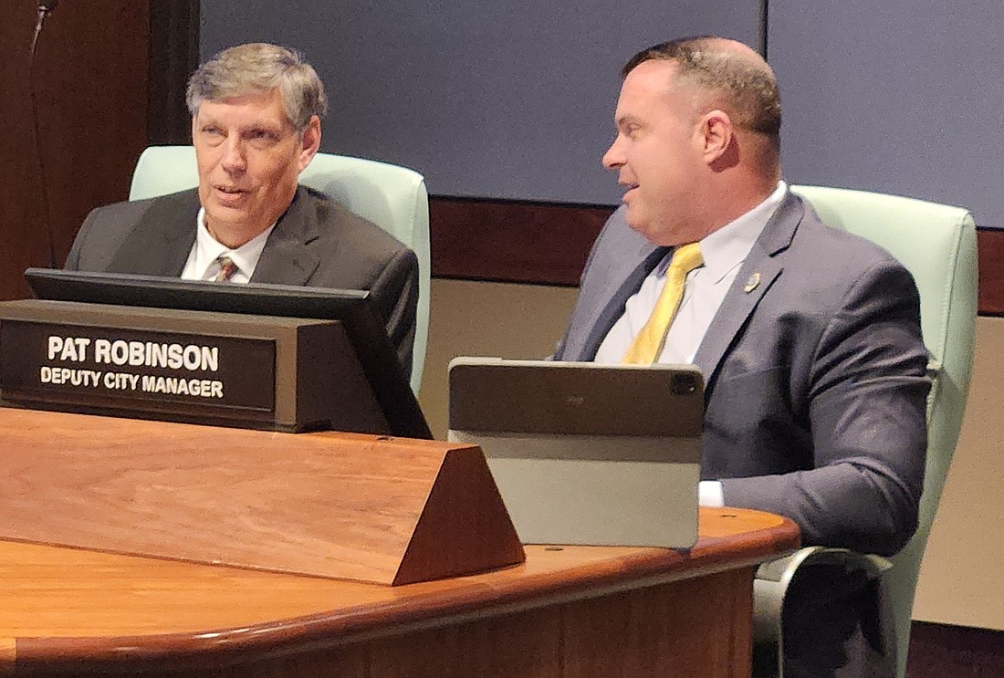 Interim City Manager Doug Jeffcoat, left, confers with Deputy City Manager Pat Robinson during a City Commission meeting in 2025.