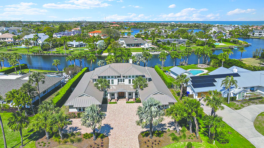 Waterfront two-story home features five bedrooms, five full and two half-bathrooms, guest suite, porches and pool.