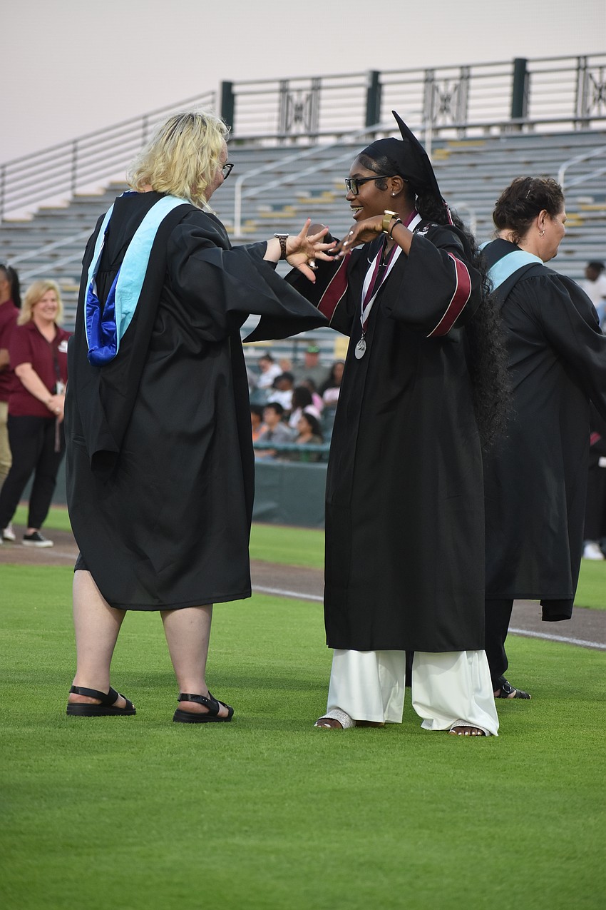 Graduate Jassee Alexis and assistant principal Laura Gonzales dance together as Alexis graduates.