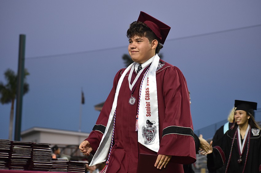 Gael Maldonado, a member of TSA, proudly walks to shake hands of school representatives.
