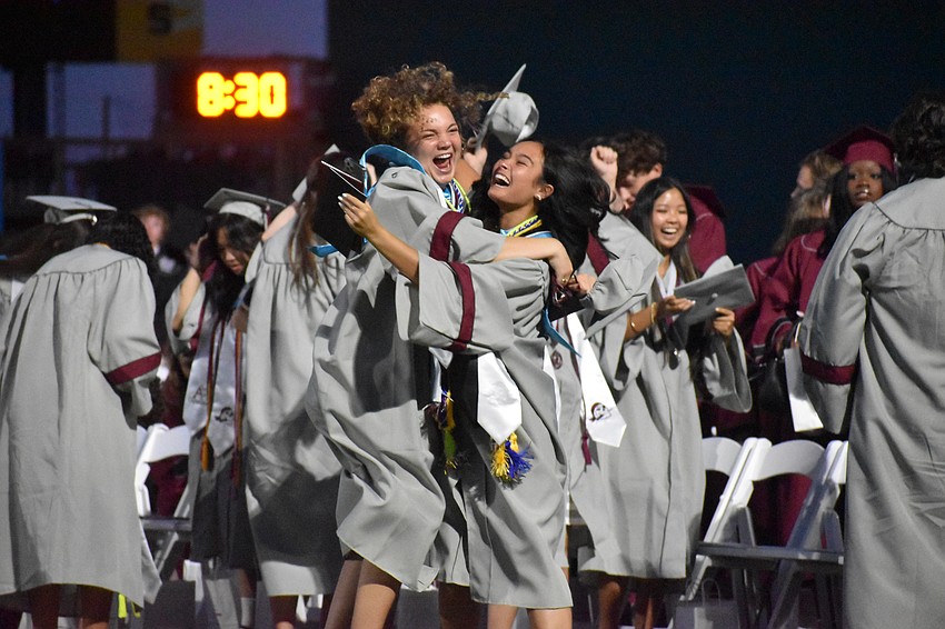 Amber DePasquale and Louann McCord jump around in excitement right after throwing up their caps to signal their gradation.