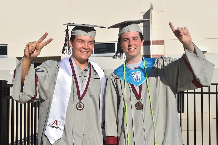 Salutatorian Grant Hicks and valedictorian James Daley hold up their fingers to represent their ranking.