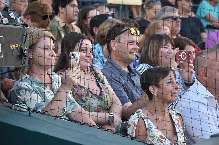 Loved ones of Ayva Culp listen to her speech and capture the moment with their phones.
